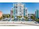 Stunning beachfront condo building featuring a mix of white and blue accents with private balconies and palm trees at 11000 Gulf Blvd # 1004, Treasure Island, FL 33706