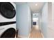 Hallway with laundry closet and a view into bedroom with sliding doors to outdoor balcony at 11000 Gulf Blvd # 1004, Treasure Island, FL 33706