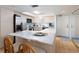 Spacious kitchen with light wood cabinetry, a marble countertop island with chairs, and modern appliances at 11000 Gulf Blvd # 1004, Treasure Island, FL 33706