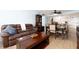 Comfortable living and dining area with a brown leather sofa, dark wood furniture, and an adjacent kitchen at 11000 Gulf Blvd # 1004, Treasure Island, FL 33706