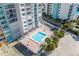Elevated view of a complex swimming pool deck surrounded by palm trees and manicured landscaping at 11000 Gulf Blvd # 1004, Treasure Island, FL 33706