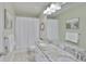 Bright bathroom featuring double sinks with granite countertop, bright white cabinetry and a shower with tub at 11044 Spring Point Cir, Riverview, FL 33579