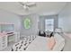 Charming bedroom featuring a unique round window, vanity table, and stylish black and white bedding at 11044 Spring Point Cir, Riverview, FL 33579