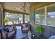 Cozy screened lanai with stylish wicker furniture, plant accents, and a serene view of the backyard at 11044 Spring Point Cir, Riverview, FL 33579