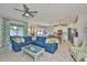 Open concept living space features a comfortable blue sectional sofa, adjacent to the bright kitchen at 11044 Spring Point Cir, Riverview, FL 33579