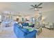 Bright living room with a blue sectional sofa and views into the modern kitchen with a large island at 11044 Spring Point Cir, Riverview, FL 33579