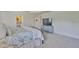Bright main bedroom with a serene decor, soft carpet, tray ceilings, and a glimpse into the ensuite bath at 11044 Spring Point Cir, Riverview, FL 33579