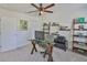 Well-lit home office featuring a glass desk, storage shelving, and comfortable carpet flooring at 11044 Spring Point Cir, Riverview, FL 33579