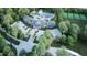 Beautiful aerial view of community clubhouse, pool, and tennis courts surrounded by lush landscaping and mature trees at 11295 Timber Grove Ln, Brooksville, FL 34613