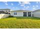 Grassy backyard includes the rear exterior and an off-white privacy fence at 11295 Timber Grove Ln, Brooksville, FL 34613
