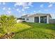 Spacious backyard with a grassy lawn, shrubbery, and rear home exterior at 11295 Timber Grove Ln, Brooksville, FL 34613