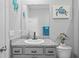 Bathroom with granite countertops, sink, toilet, and large mirror at 11295 Timber Grove Ln, Brooksville, FL 34613