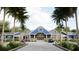 Exterior view of community center with palm trees and beautifully landscaped front entrance and parking at 11295 Timber Grove Ln, Brooksville, FL 34613