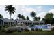 Community pool area featuring beautiful blue flowers, tall palm trees, and ample room to relax and enjoy the water at 11295 Timber Grove Ln, Brooksville, FL 34613