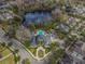 Aerial view of community pool and clubhouse surrounded by lush greenery and houses, showcasing the neighborhood's amenities at 11317 Wickersley Pl, Tampa, FL 33625
