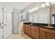 Bright bathroom with double sinks, a glass-enclosed shower, and granite counters at 11317 Wickersley Pl, Tampa, FL 33625