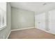 A carpeted bedroom with neutral walls and a double doored closet at 11317 Wickersley Pl, Tampa, FL 33625