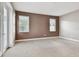 Spacious carpeted bedroom with two windows, a white door, and neutral walls at 11317 Wickersley Pl, Tampa, FL 33625