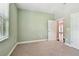 Neutral carpeted bedroom featuring pale green walls, a closet, and an open doorway at 11317 Wickersley Pl, Tampa, FL 33625