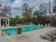 Community pool surrounded by lounge chairs and lush landscaping, creating a relaxing atmosphere at 11317 Wickersley Pl, Tampa, FL 33625