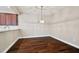 Dining area showcasing hardwood floors and an elegant light fixture with adjacent kitchen at 11317 Wickersley Pl, Tampa, FL 33625