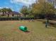 Aerial view of a fenced dog park with chairs, green tunnel and other play structures and lush green grass at 11317 Wickersley Pl, Tampa, FL 33625