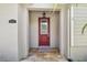 Inviting front entryway with a red door, stone flooring, and a decorative light fixture at 11317 Wickersley Pl, Tampa, FL 33625