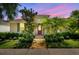 Charming home with a red front door, manicured landscaping, palm trees, and a brick walkway at 11317 Wickersley Pl, Tampa, FL 33625