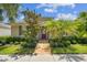 Charming home showcasing lush landscaping, a brick walkway, and a cozy covered entry at 11317 Wickersley Pl, Tampa, FL 33625