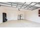A two car garage featuring speckled flooring, shelves, a water heater and a refrigerator at 11317 Wickersley Pl, Tampa, FL 33625