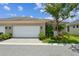 Charming home featuring an attached two-car garage and beautifully landscaped front yard with mature tree at 11317 Wickersley Pl, Tampa, FL 33625