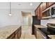 Kitchen featuring stainless steel appliances, granite countertops, and dark wood cabinets at 11317 Wickersley Pl, Tampa, FL 33625