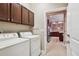Laundry room with modern washer and dryer, and access to kitchen area at 11317 Wickersley Pl, Tampa, FL 33625