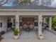 Covered outdoor kitchen and dining area with stainless steel grills, ceiling fans, and ample seating at 11317 Wickersley Pl, Tampa, FL 33625
