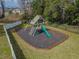 Aerial view of a wooden playset with a slide and swings, surrounded by dark mulch and a fenced-in yard at 11317 Wickersley Pl, Tampa, FL 33625