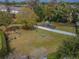 Aerial view of a fenced playground with a swing set, slide, and circular seating area within a grassy field at 11317 Wickersley Pl, Tampa, FL 33625