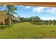 Expansive backyard featuring lush green grass, mature trees, and a serene pond view at 12710 Buffalo Run Drive, Gibsonton, FL 33534