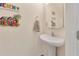 Cozy powder room featuring pedestal sink and charming beach-themed decorations for a refreshing ambiance at 12710 Buffalo Run Drive, Gibsonton, FL 33534