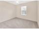 Cozy bedroom with neutral carpet, ceiling fan, and a large window overlooking the landscaped yard at 12710 Buffalo Run Drive, Gibsonton, FL 33534