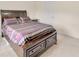 Carpeted bedroom featuring a bed with striped comforter and dark wood frame with drawer storage at 12710 Buffalo Run Drive, Gibsonton, FL 33534