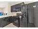 Modern kitchen with black cabinetry, sleek appliances, and ample counter space for meal preparation at 12710 Buffalo Run Drive, Gibsonton, FL 33534