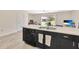 Kitchen island with sink, dishwasher, black cabinets, bar seating, and view to the backyard at 12710 Buffalo Run Drive, Gibsonton, FL 33534