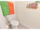 Powder room with a standard toilet, tiled floors, and decorative wall art at 12710 Buffalo Run Drive, Gibsonton, FL 33534