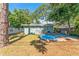 Backyard featuring green siding, lush trees, and the house's exterior at 1327 S Michigan Ave, Clearwater, FL 33756