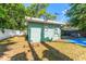 Backyard view showcasing green siding, lush trees, and the house's overall setting at 1327 S Michigan Ave, Clearwater, FL 33756