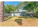 The backyard features a large lawn, mature trees, and a charming light blue home exterior at 1327 S Michigan Ave, Clearwater, FL 33756