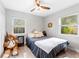 Charming bedroom with plush bedding, ceiling fan, and natural light from the two large windows at 1327 S Michigan Ave, Clearwater, FL 33756