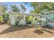 Well-maintained home showing a covered porch, tidy landscaping with palms, and light-green siding at 1327 S Michigan Ave, Clearwater, FL 33756