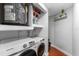 Functional laundry room with a modern washer and dryer, storage shelves, and water heater at 1327 S Michigan Ave, Clearwater, FL 33756