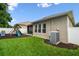 Backyard with a playset, white fence, lawn, and a view of the screened lanai at 13310 Tiger Lilly Ln, Tampa, FL 33625